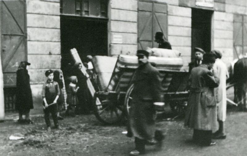 Displacements from Oświęcim. Horse-drawn ladder cart loaded with furniture and mattresses. There are people walking around the cart, men in coats, women and children.
