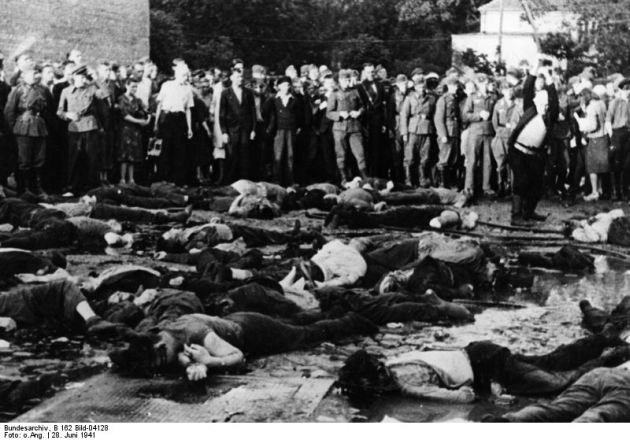 The site after the execution. Bloody bodies of people lying in the square, behind them German soldiers standing in uniforms and civilians, men and women.