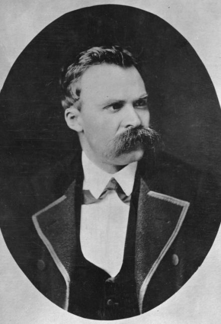 Portrait photograph of a middle-aged man. Gaze directed to the right side. A serious expression on his face. Slender face, catfish mustache.