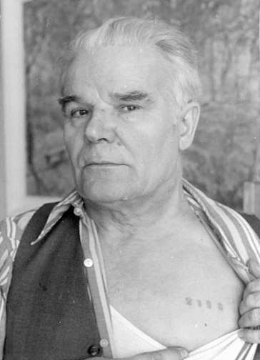 Former Soviet prisoner of war Stanisław Aleksandrowicz opens his shirt and shows the number tattooed on the left side of his chest.