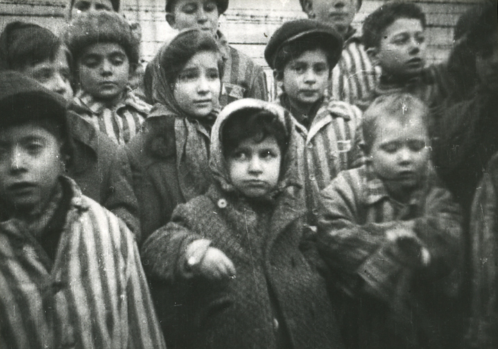 Auschwitz I. A group of liberated children in the camp dressed in oversized striped prisoner clothing.