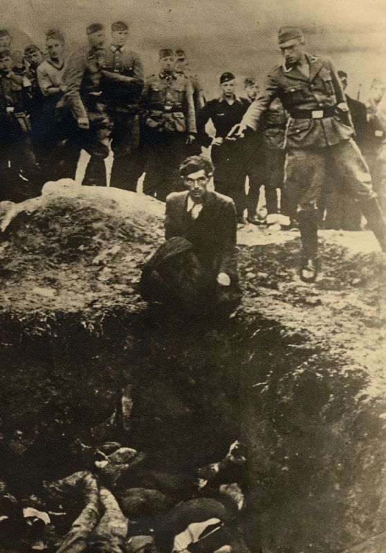 In the foreground a pit filled with the bodies of murdered people. A man is sitting in front of the pit. Above him a German soldier is holding a pistol to his head. In the background soldiers observing the situation.
