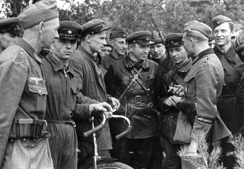 German and Soviet soldiers talking to each other. Some are smiling.