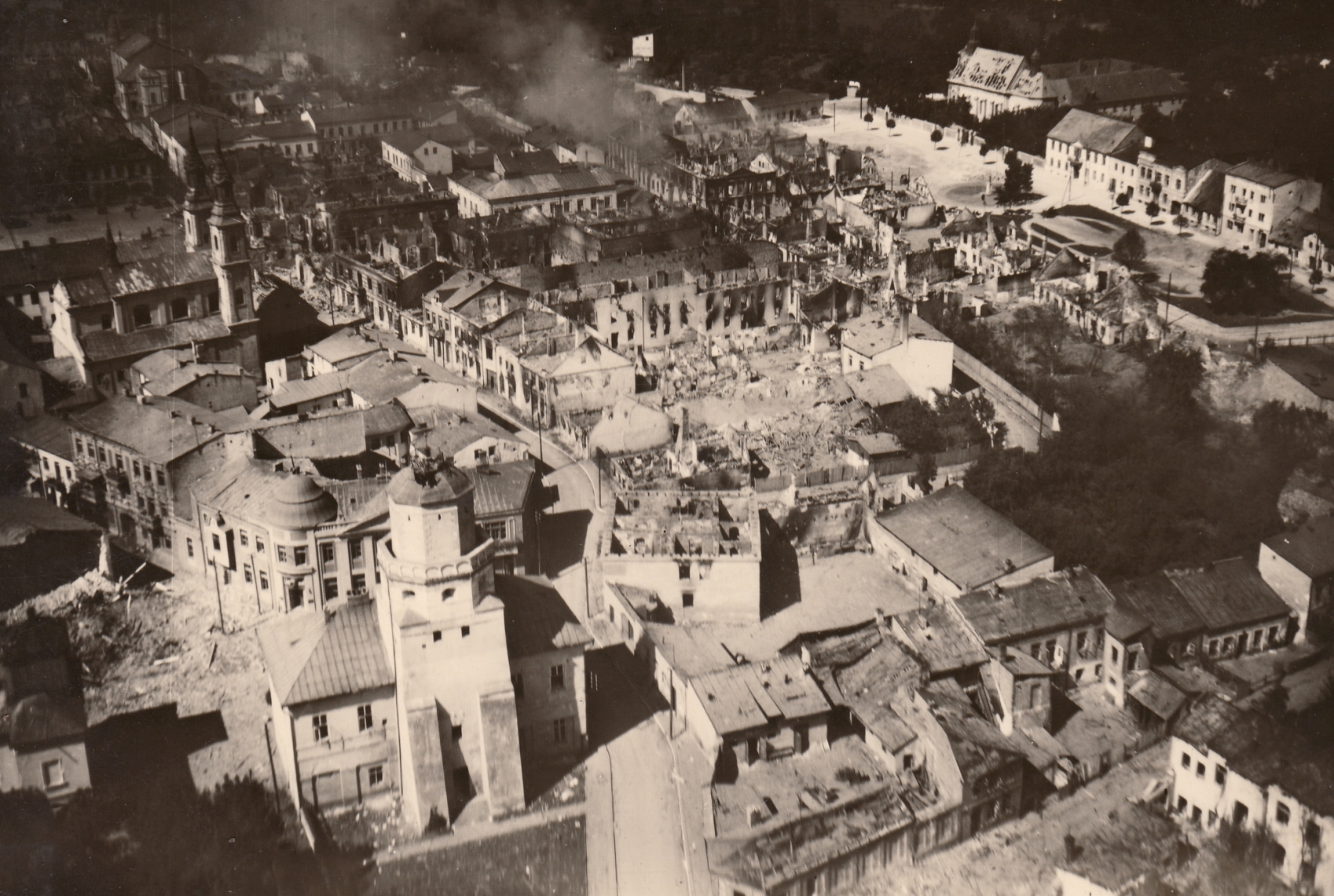 Bombed city shown from above. Deserted, bombed buildings, piles of bricks.