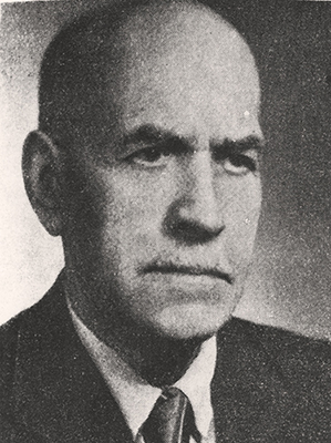 Portrait of a middle-aged man. Dressed in a suit, a shirt and a tie. Eyes turned to the side, serious expression.
