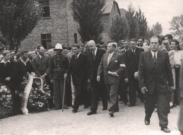 Tłum osób zwiedzających Miejsce Pamięci Auschwitz I. Na pierwszym planie premier Józef Cyrankiewicz, po prawej dyrektor Muzeum. 