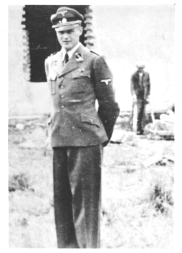 Eduard Wirths 
A middle-aged man in a German SS uniform and a cap with a skull, remains serious. A photo taken with a building in the background. Another man standing in the distance, leaning on crutches.