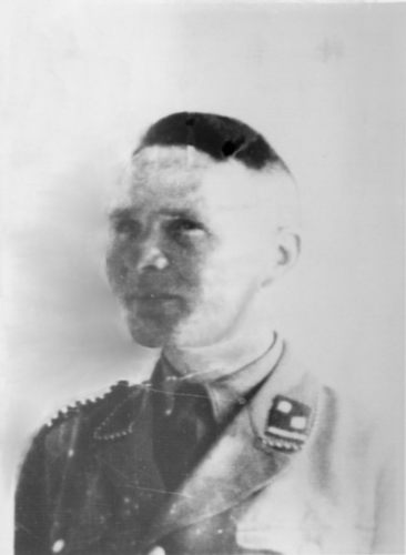 Rudolf Höss
A middle-aged man in a German SS uniform, remains serious. Glancing at the side of the camera. Dark hair, combed back smoothly.