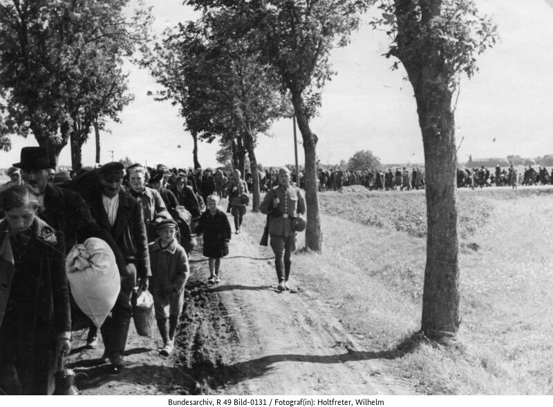 Crowds of civilians on the gravel road.
