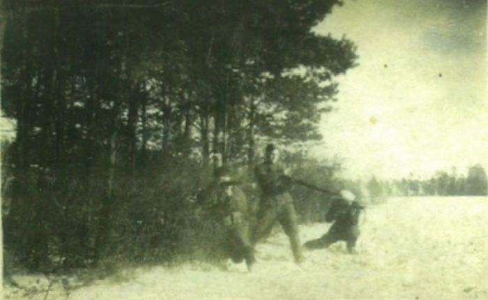 Three men at the edge of the forest aim their rifles at the right flank.